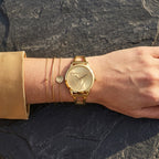 ساعة نسائية Guess W1145L3 بسوار ذهبي وشعار مثلث ذهبي وهيكل ذهبي